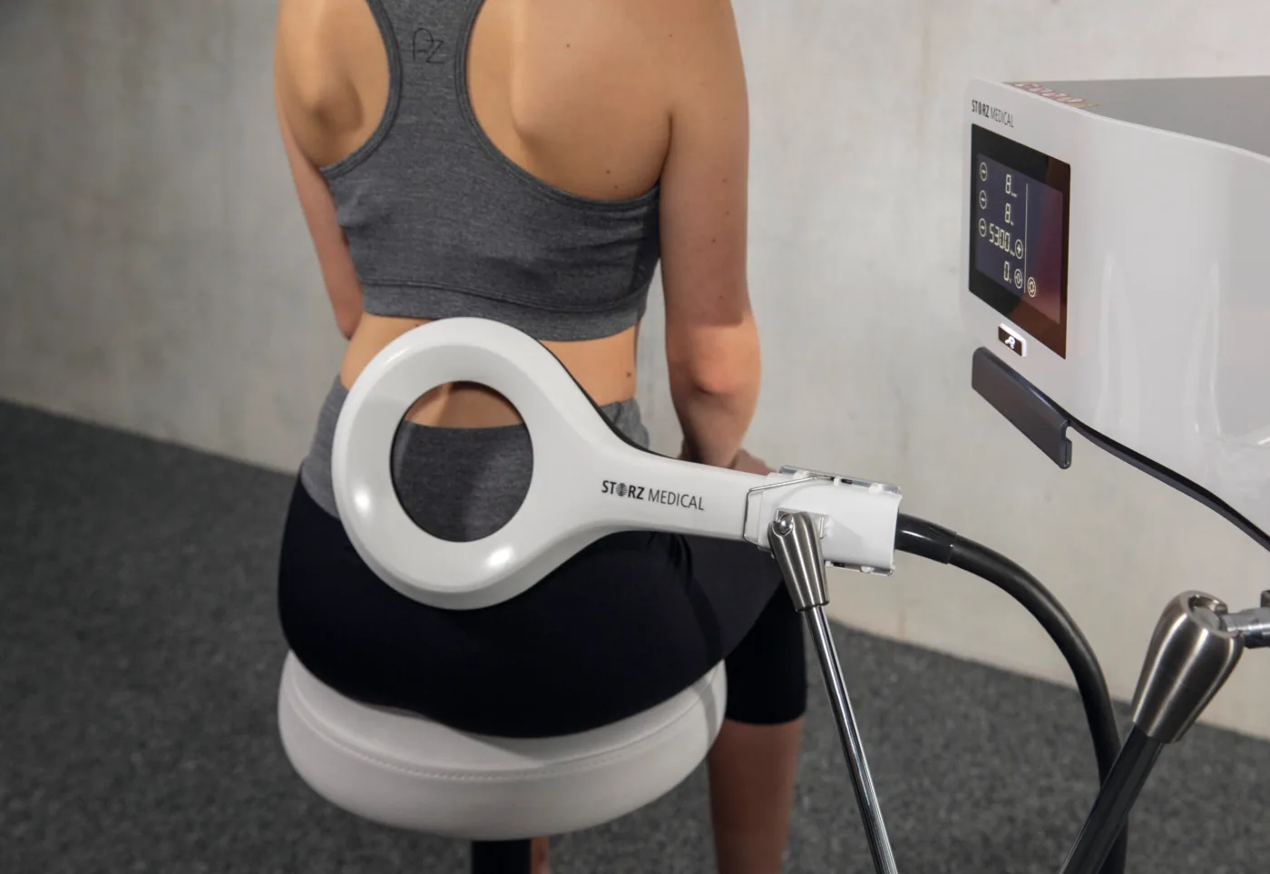 Storz Medical EMTT machine with its ring applicator positioned over the lower back