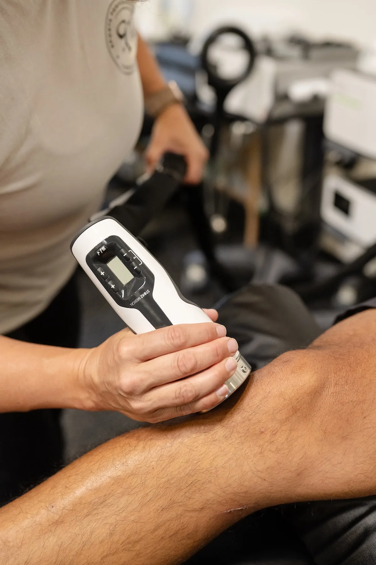 Sports Performance physical therapist delivering a focused shockwave therapy session in Chula Vista