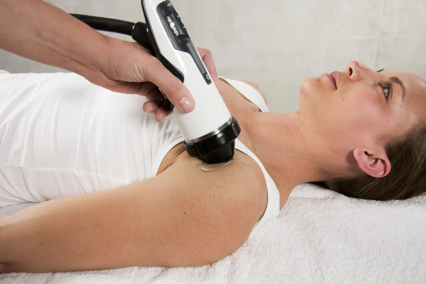 Focused shockwave therapy handpiece treating the rotator cuff at the front of the shoulder