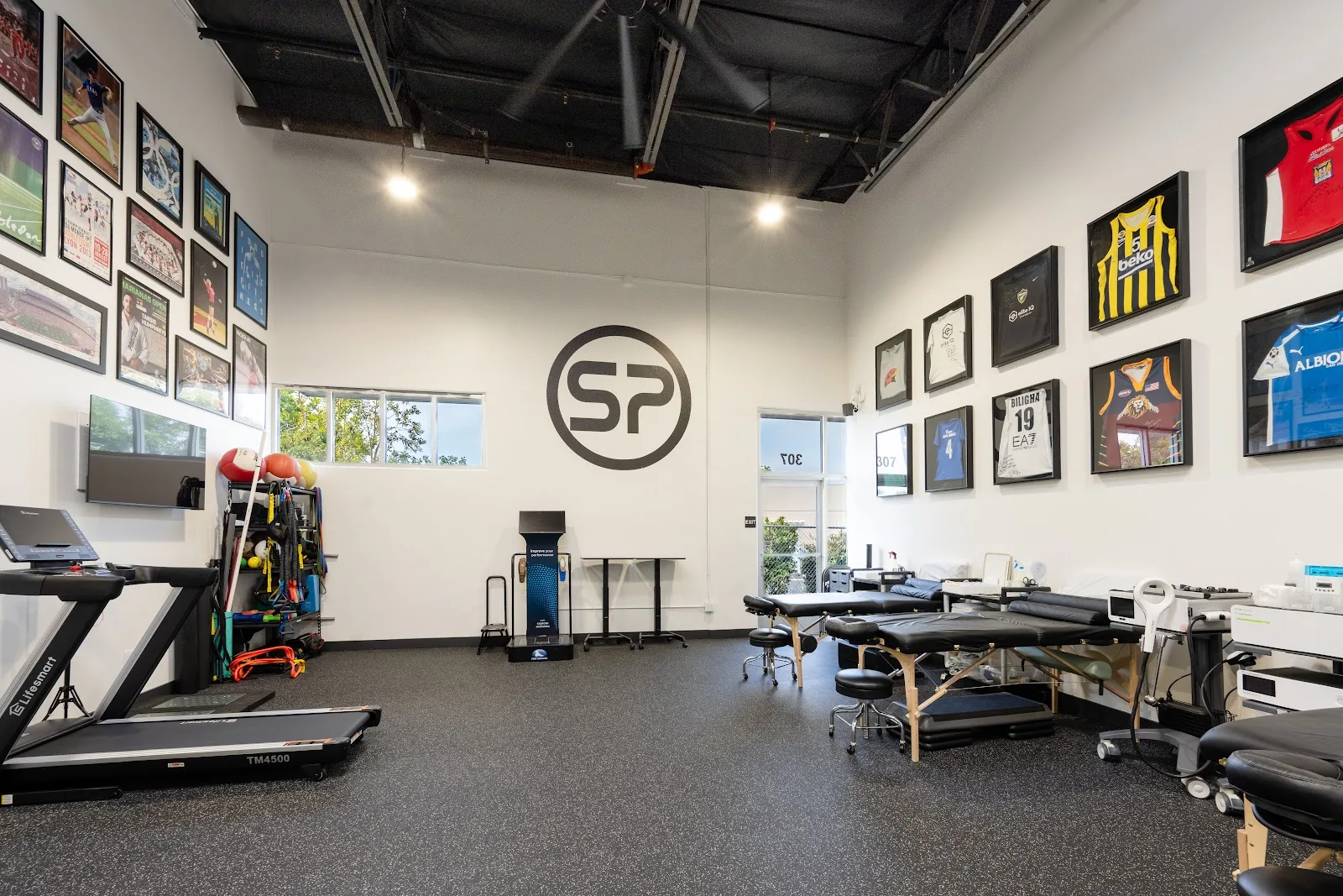 Open treatment floor with private tables and rehab equipment at Sports Performance Physical Therapy in Chula Vista